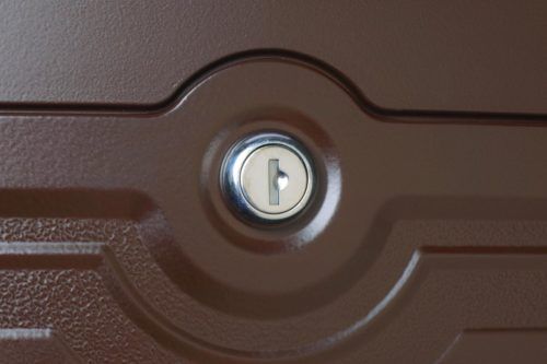 Zoomed in image of lock of brown wall mount mailbox