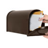 Open bronze mailbox with mail being delivered inside