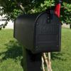 black aluminum mailbox on lawn with flag raised